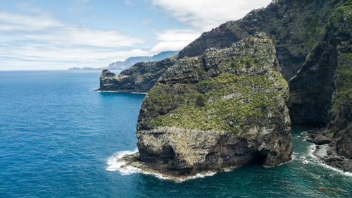 Rock formation in sea against sky