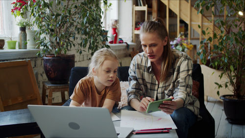 Mother teaching daughter at home