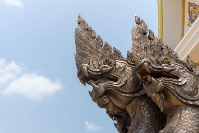 Low angle view of sculpture on building against sky