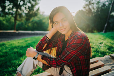 Portrait of smiling young woman sitting outdoors