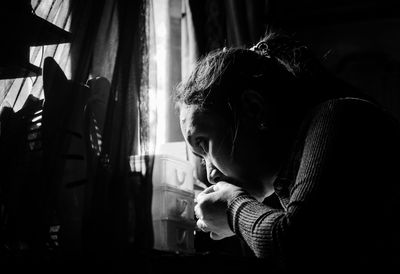 Rear view of woman looking through window