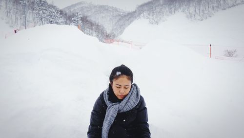 Young woman standing on snowcapped mountain