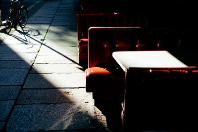 Empty chairs and table at sidewalk cafe in city