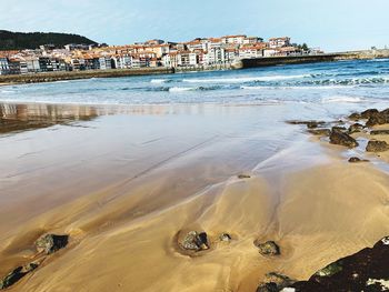 Scenic view of beach and buildings against sky