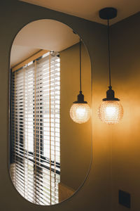 Illuminated lamp hanging on ceiling of building