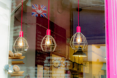 Illuminated pendant lights hanging from glass window