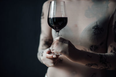 Midsection of woman drinking glass