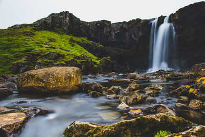 Scenic view of waterfall against rocks