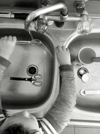 High angle view of young boy at kitchen sink