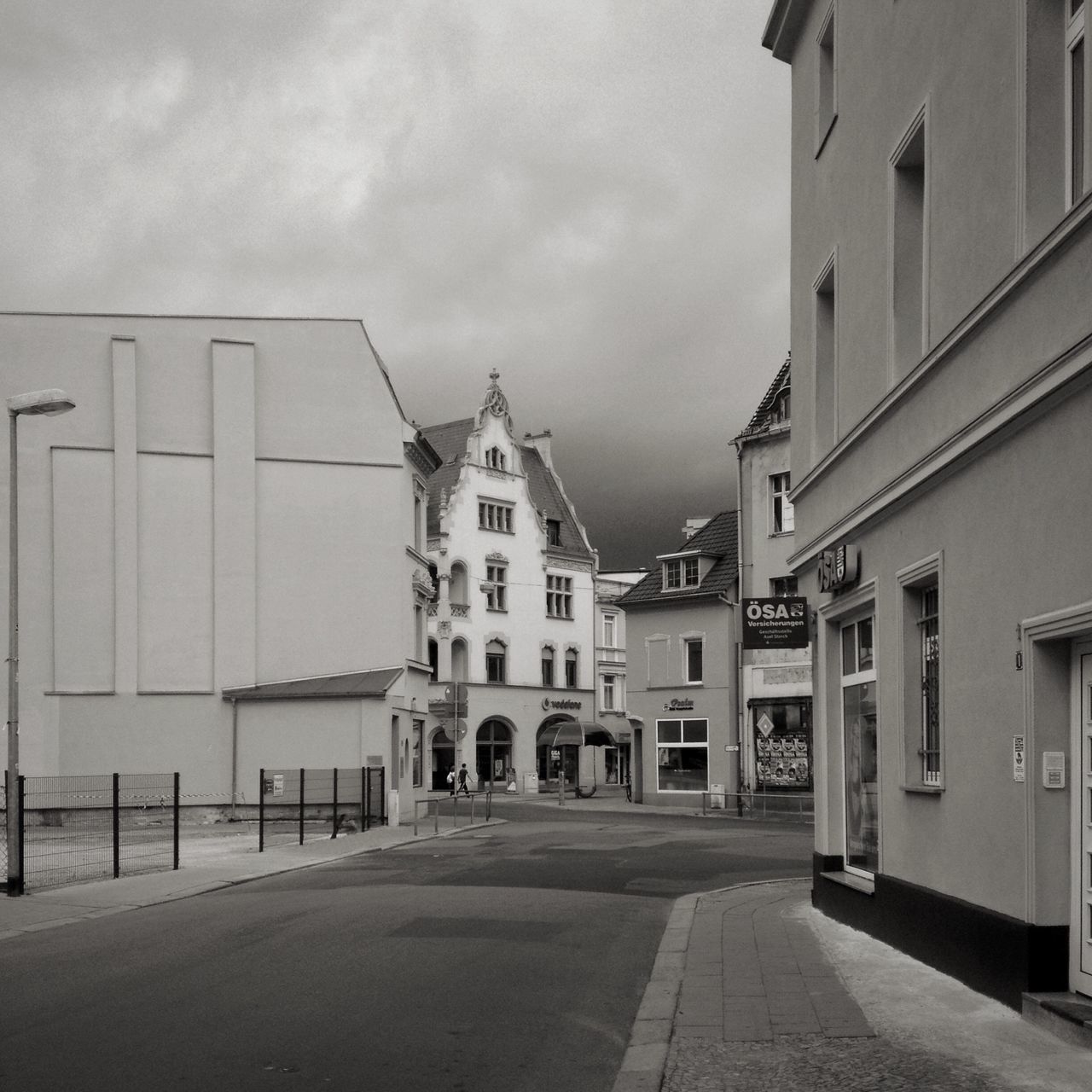 architecture, building exterior, built structure, sky, the way forward, street, building, city, cloud - sky, diminishing perspective, road, residential structure, outdoors, residential building, day, empty, cobblestone, facade, no people, cloudy