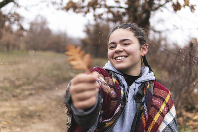 Portrait of smiling woman standing on field