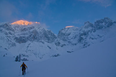 People skiing on snowcapped mountain against sky