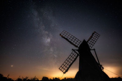 Low angle view of silhouette traditional windmill against sky at night