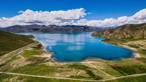 Scenic view of lake and mountains against blue sky