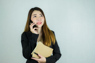 Portrait of a smiling young woman against white background