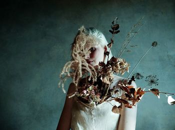 Portrait of woman holding plant