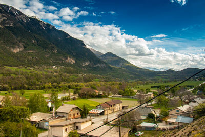 Scenic view of townscape and mountains against sky