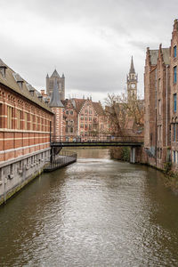 Bridge over river against buildings in city