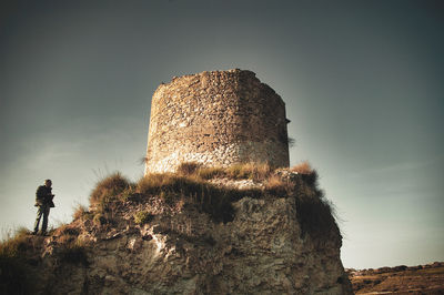 Low angle view of old ruin standing on field against sky