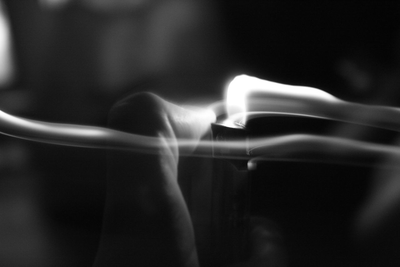 CLOSE-UP OF PERSON HAND ON BURNING CANDLE