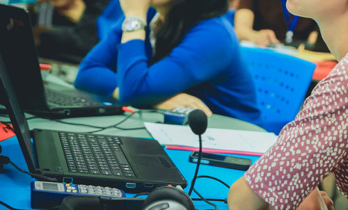 Midsection of businesswoman using laptop while working in office