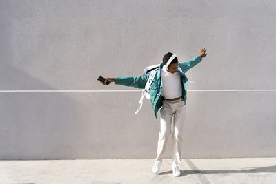 Full length of man standing against wall