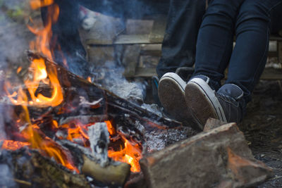 Low section of people sitting near bonfire