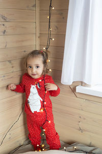 Portrait of cute girl playing with teddy bear at home