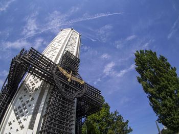 Low angle view of skyscrapers against cloudy sky