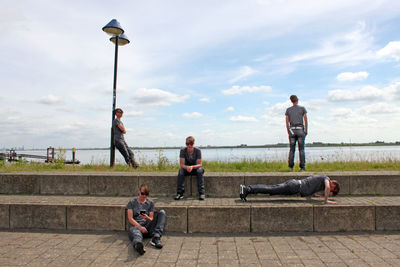 Multiple image of young man at footpath against sky