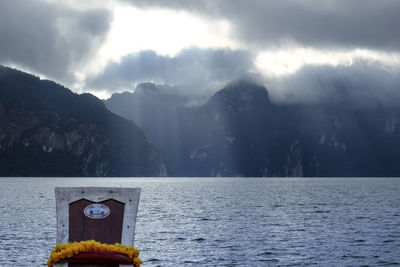 Scenic view of sea and mountains against sky