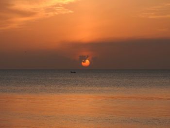 Scenic view of sea against orange sky