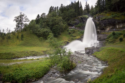 Scenic view of waterfall against trees