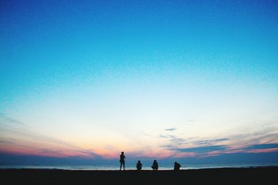 Silhouette of people standing on beach