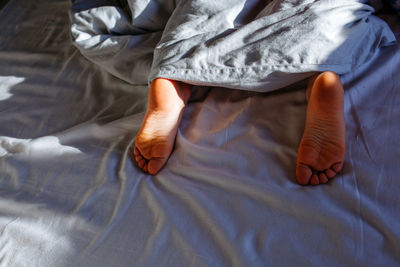 Child's feet under the blanket in the early morning light