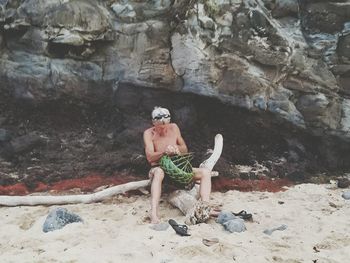 Portrait of man sitting on rock