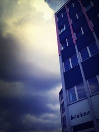 Low angle view of modern building against cloudy sky