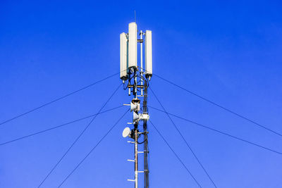 Low angle view of repeater tower against clear blue sky