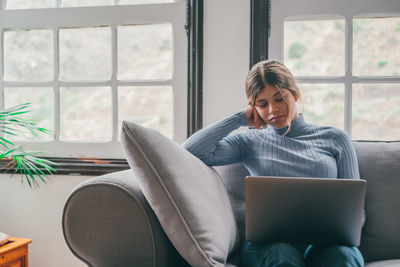 Young woman using laptop at home