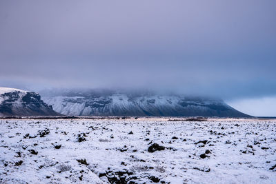 Snow covered field against sky