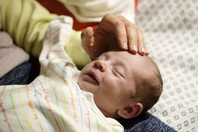 Close-up of baby sleeping on bed