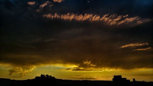 Low angle view of silhouette landscape against cloudy sky