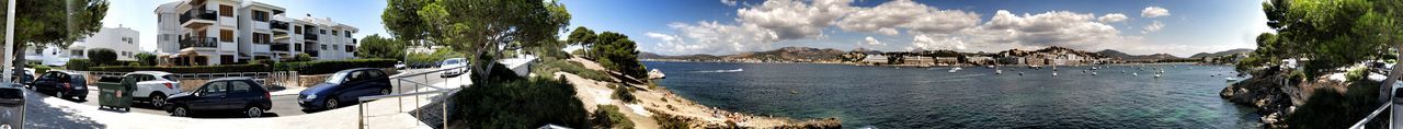 Panoramic shot of city by sea against sky