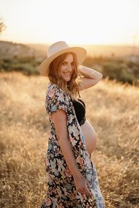 Portrait of smiling young woman standing on field