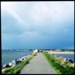 Surface level of road against cloudy sky