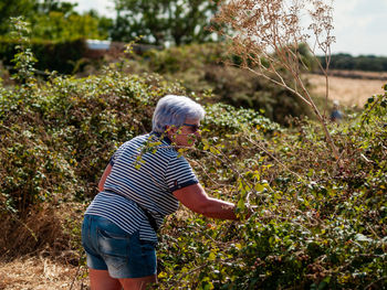 Senior woman gardening on field