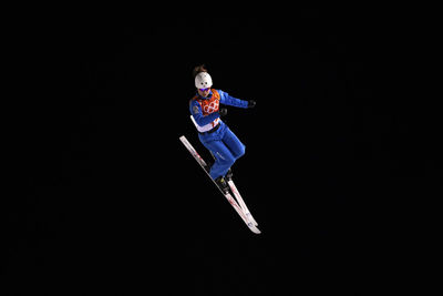 Low angle view of paragliding over black background