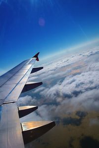 Cropped image of airplane flying over clouds