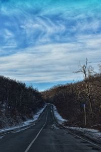 Road amidst trees against sky