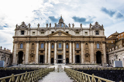 Empty chairs by st peters basilica against sky